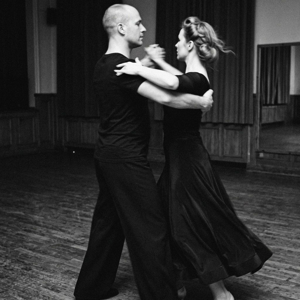 Ballroom dancing couple in close hold practicing on the dance floor
